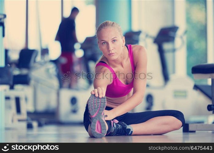 Cute young woman stretching and warming up for her training at a gym. woman stretching and warming up for her training at a gym