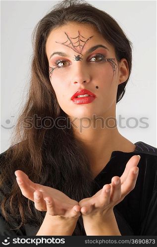 cute young woman with a spider web painted on face