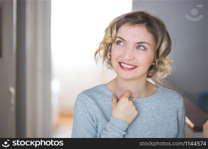 Cute young woman with blonde curly hair is thinking about her life. Closeup.