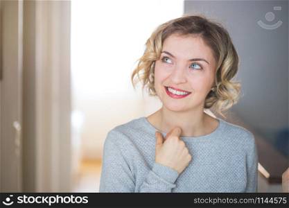 Cute young woman with blonde curly hair is thinking about her life. Closeup.
