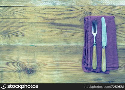 Cutlery and napkin on wooden background.. Cutlery and napkin on wooden background