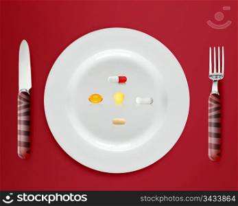 cutlery and plate with pills and capsules on red background.