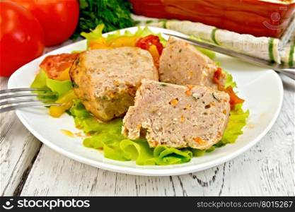 Cutlet of turkey meat with lettuce, tomato and yellow pepper in a dish, parsley, a towel and a fork on the background of wooden boards