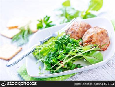 cutlets with salad on plate and on a table