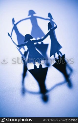 Cutout paper females standing in a circle holding hands.