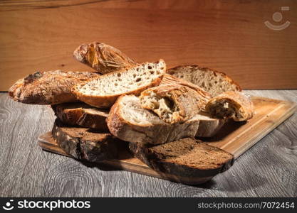 cuttind bread cereal baguette and fig bread with prunes on wooden background