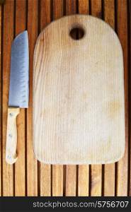 cutting board and knife on wooden background