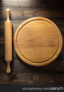 cutting board and rolling pin at brown background texture