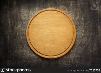 cutting board at old wooden table background, top view