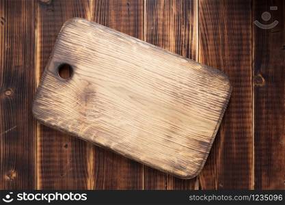 cutting board at rustic wooden plank background, top view