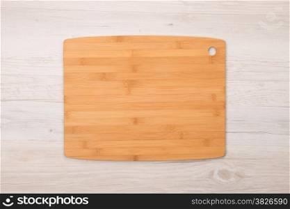 Cutting board on wooden background.