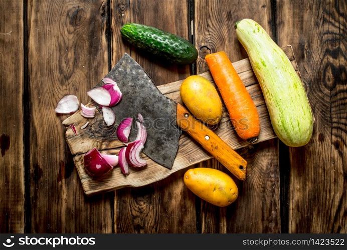Cutting fresh vegetables for soup. On a wooden table.. Cutting fresh vegetables for soup.
