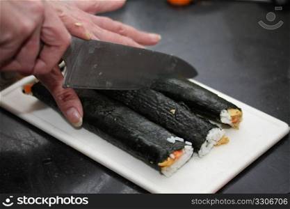 Cutting makisushi: fish, rice and other ingredients rolled in seaweed