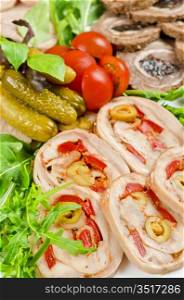Cutting meat tenderloin stuffed with prune and peper and olive with lettuce, tomatoes, cucumbers and ruccola