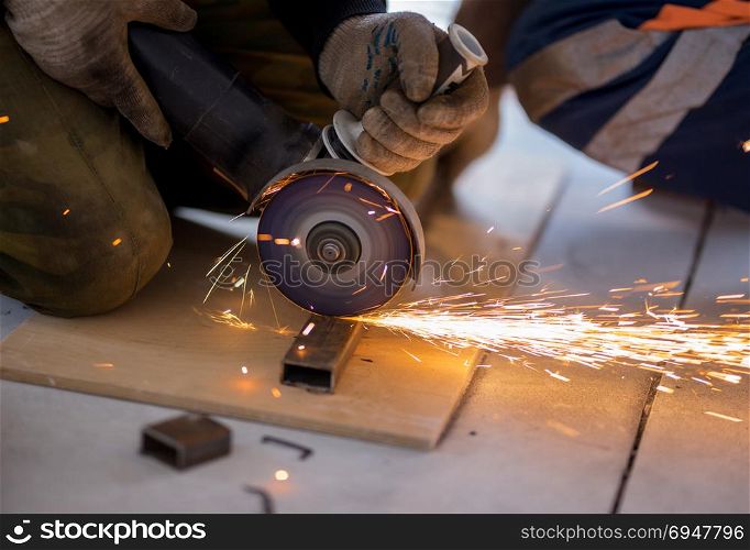 Cutting metal with angle grinder.. Cutting rectangular metal pipe with angle grinder.