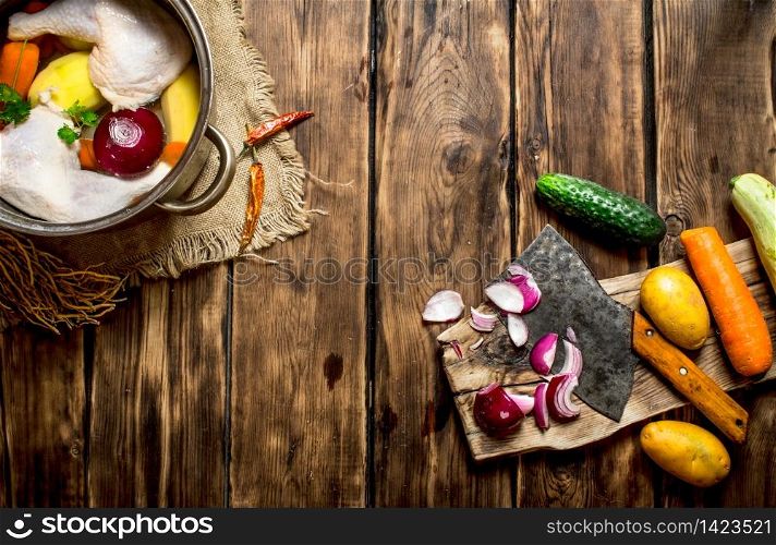 Cutting of vegetables to chicken broth. On a wooden table.. Cutting of vegetables to chicken broth.