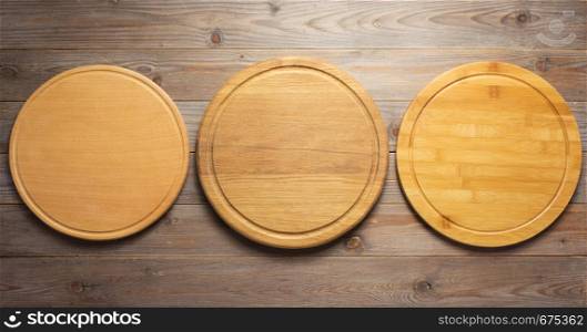 cutting pizza board at wooden plank table board background, top view