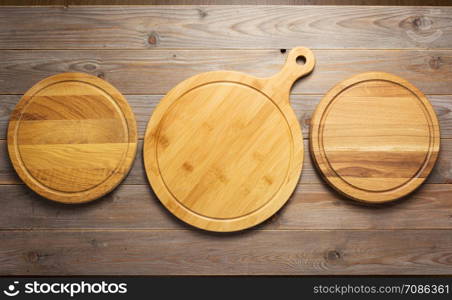cutting pizza board at wooden plank table board background, top view
