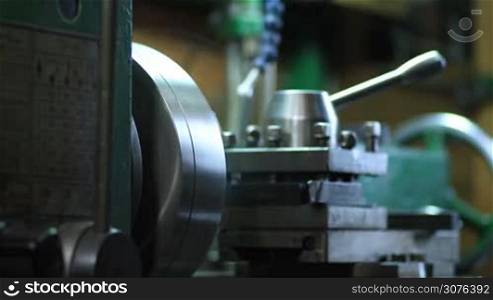 Cutting steel metal shaft processing on lathe machine. Details and tools of old turning lathe machine drilling and turning workpiece with metal cutter.