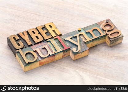 cyber bullying word abstract- text in vintage letterpress wood type printing blocks stained by color inks
