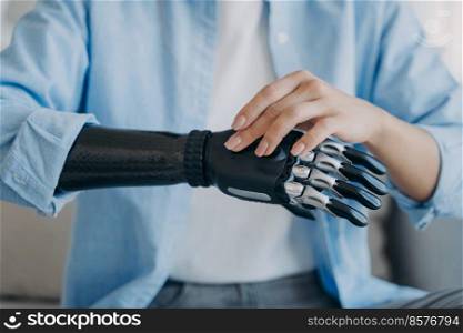 Cyber hand of female&utee. Disabled woman is changing settings of bionic arm. Electronic sensor hand has processor and buttons. High tech carbon robotic prosthesis. Medical technology and science.. Cyber hand of female&utee. Disabled woman is changing settings of robotic prosthesis.