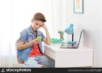 cyberbullying, people and communication concept - boy with smartphone being bullied by text message at home. boy with smartphone being bullied by text message