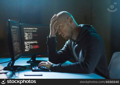 cybercrime, hacking and technology concept - male hacker in dark room having problem with computer virus program for cyber attack. hacker having problem with computer cyber attack. hacker having problem with computer cyber attack