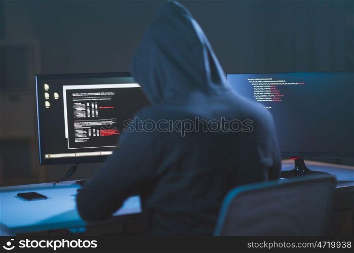 cybercrime, hacking and technology concept - male hacker in dark room writing code or using computer virus program for cyber attack. hacker using computer virus for cyber attack. hacker using computer virus for cyber attack