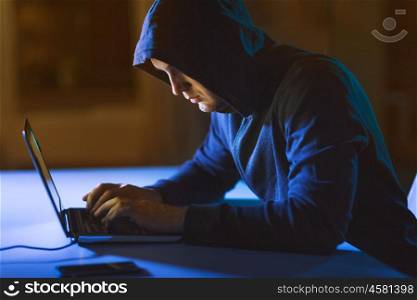 cybercrime, hacking and technology crime - male hacker in dark room using laptop computer for cyber attack. hacker using laptop computer for cyber attack. hacker using laptop computer for cyber attack
