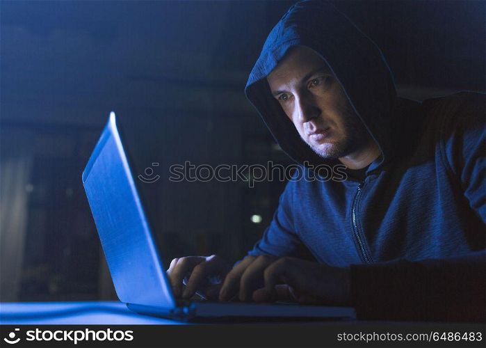 cybercrime, hacking and technology crime - male hacker in dark room using laptop computer for cyber attack. hacker using laptop computer for cyber attack. hacker using laptop computer for cyber attack