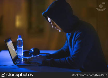 cybercrime, hacking and technology crime - male hacker in dark room using laptop computer for cyber attack. hacker using laptop computer for cyber attack. hacker using laptop computer for cyber attack