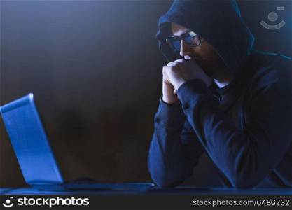 cybercrime, hacking and technology crime - male hacker in dark room with laptop computer. hacker with laptop computer in dark room. hacker with laptop computer in dark room