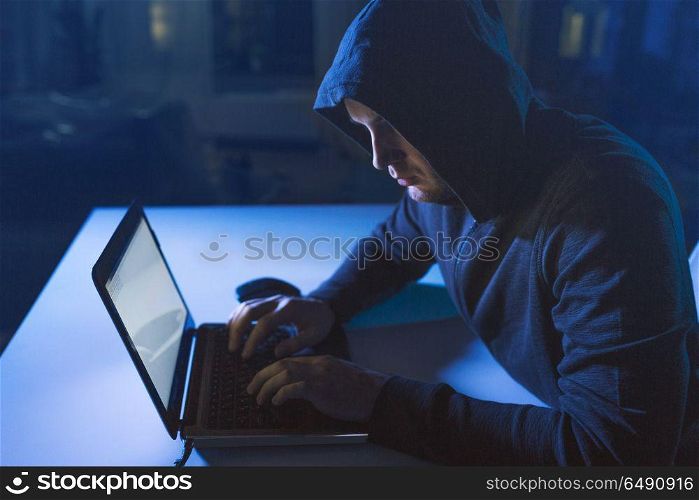 cybercrime, hacking and technology crime - male hacker in dark room writing code or using laptop computer for cyber attack. hacker using laptop computer for cyber attack. hacker using laptop computer for cyber attack