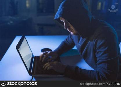 cybercrime, hacking and technology crime - male hacker in dark room writing code or using laptop computer for cyber attack. hacker using laptop computer for cyber attack. hacker using laptop computer for cyber attack