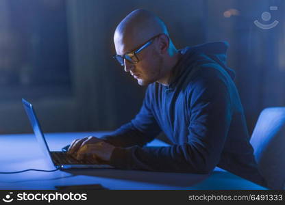 cybercrime, hacking and technology crime - male hacker in dark room writing code or using computer for cyber attack. hacker using laptop computer for cyber attack. hacker using laptop computer for cyber attack