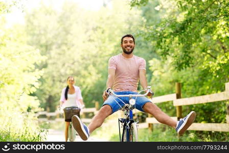 cycling, leisure and lifestyle concept - happy young couple with bicycles at summer park. happy couple with bicycles at summer park