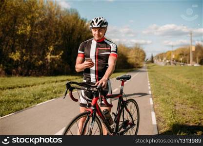 Cyclist in helmet and sportswear, training on track bike. Male sportsman rides on bicycle. Workout on bike path