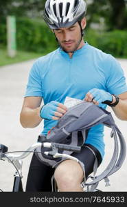 cyclist sat on bicycle looking at a map for directions