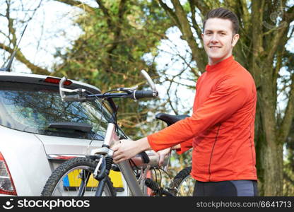 Cyclist Taking Mountain Bike From Rack On Car