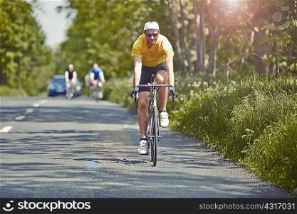 Cyclists riding on single carriageway, Cotswolds, UK