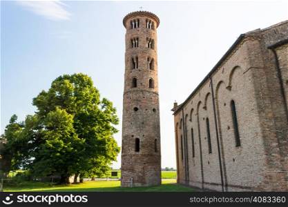 Cylindrical bell tower (VIII-IX centuries) of countryside church of Campanile, located in the village of Santa Maria in Fabriago in Emilia Romagna region in northern Italy: windows with one, two and three lights in traditional romanesque style from bottom to top