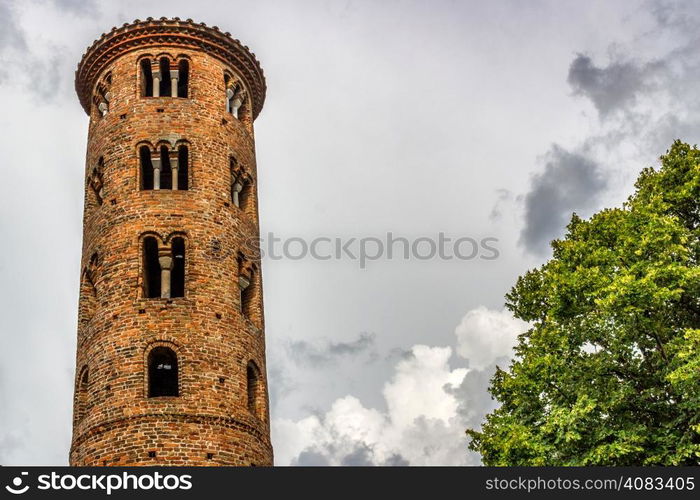 Cylindrical bell tower (VIII-IX centuries) of countryside church of Campanile, located in the village of Santa Maria in Fabriago in Emilia Romagna region in northern Italy: windows with one, two and three lights in traditional romanesque style from bottom to top