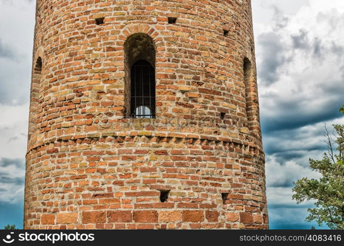 Cylindrical bell tower (VIII-IX centuries) of countryside church of Campanile, located in the village of Santa Maria in Fabriago in Emilia Romagna region in northern Italy: windows with one, two and three lights in traditional romanesque style from bottom to top