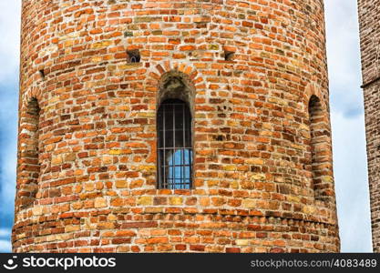 Cylindrical bell tower (VIII-IX centuries) of countryside church of Campanile, located in the village of Santa Maria in Fabriago in Emilia Romagna region in northern Italy: windows with one, two and three lights in traditional romanesque style from bottom to top