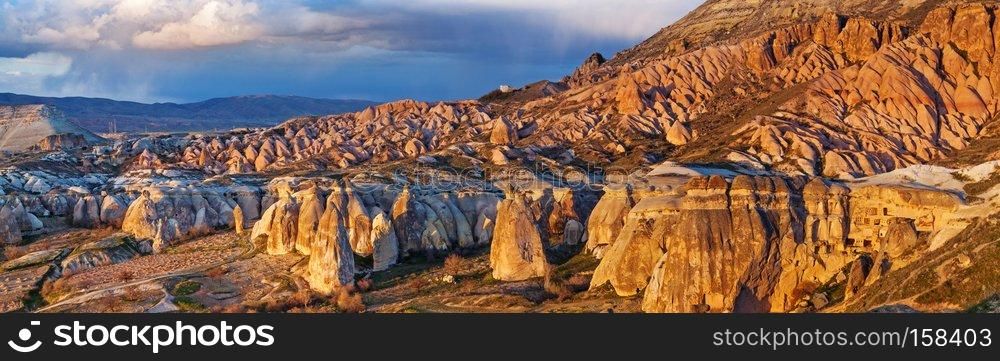Cylindrical stone cliffs and cave houses near Goreme, Turkey. Fairy houses stone cliffs