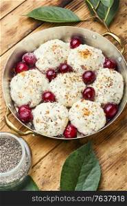 Czech dumplings or knedliky with cherry filling on wooden table. Delicious sweet cherry dumplings