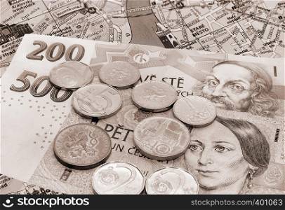 Czech money, banknotes and coins on Prague map with landmarks, Czech Republic, travel toned background