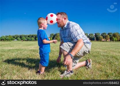 Dad and son play together with the ball