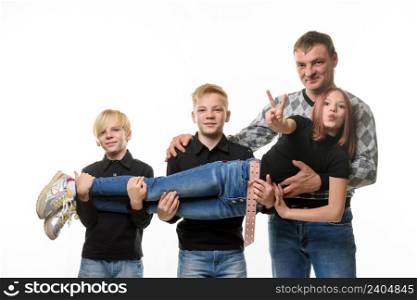 Dad and two sons hold a teenage girl in their arms, girl casual clothes in dark colors, white background