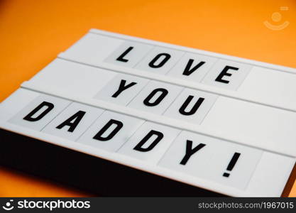 Dad day sign over a pastel pink background says love you daddy, love concept, minimal, copy space, style design